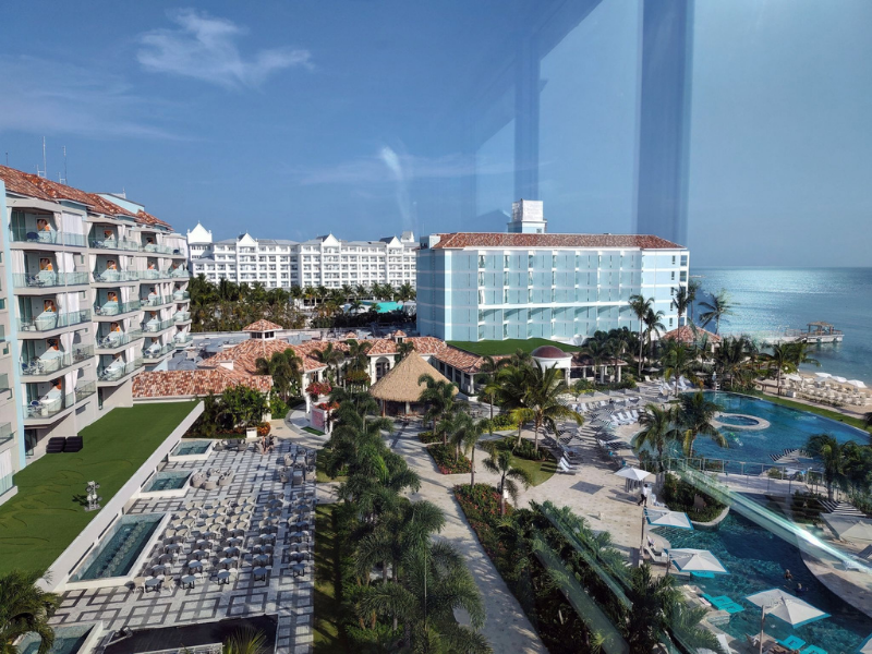 View of Sandals Dunn's River in Ocho Rios, Jamaica, showing resort pools, guest accommodations, and the Caribbean Sea.